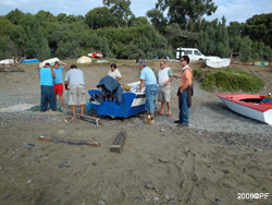 Happy fishermen fix a boat and nets after fishing tour